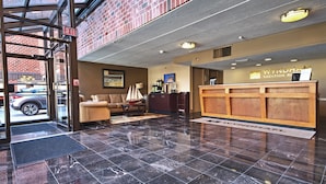 A reception area with a wooden reception desk, a sofa, and a coffee table.