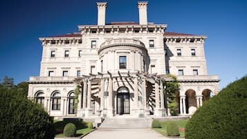 A large, stately building with a grand entrance, multiple windows, and a symmetrical facade.