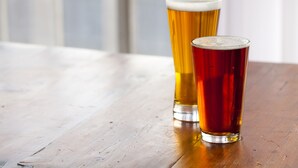 Two glasses of beer on a wooden table. - The Chelsean New York (New York)