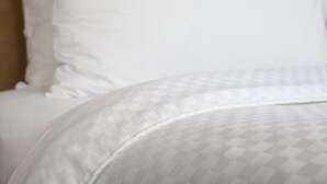 A bed with a patterned bedspread and pillows. - The Chelsean New York (New York)