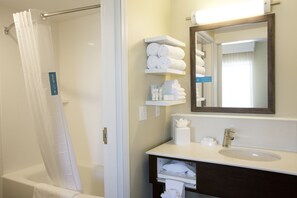 A bathroom with a shower, a sink, a mirror, and shelves with towels. - Hampton Inn & Suites Boise/Nampa at the Idaho Center (Nampa)