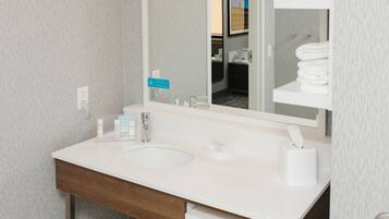 Une salle de bain moderne avec un double vasque, un grand miroir et un porte-serviettes.