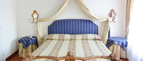 A bed with a canopy, two bedside tables, and a decorative headboard.