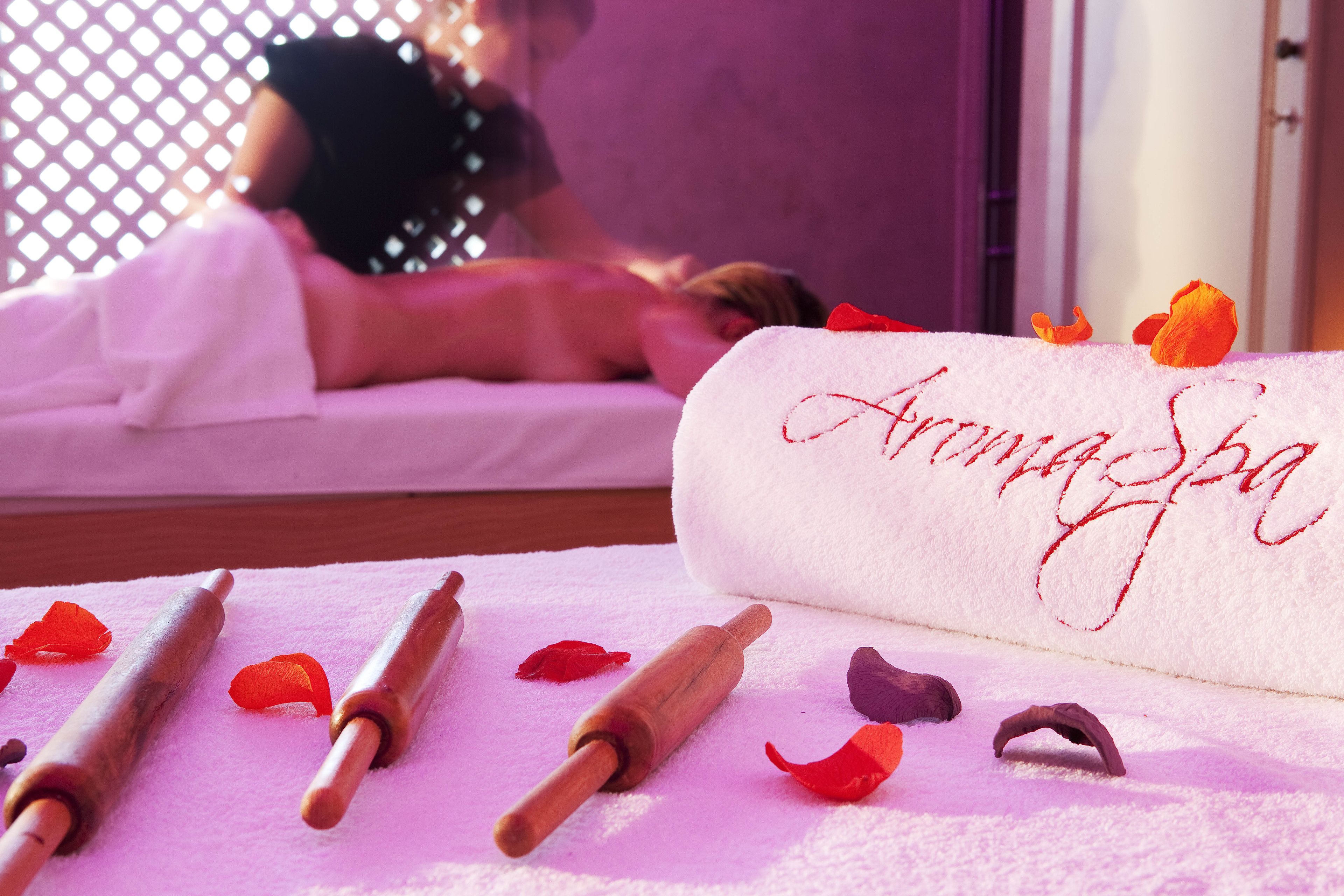 Un cuarto de spa con una camilla de masaje, una toalla bordada con 'Annapurna' y utensilios de masaje de madera.