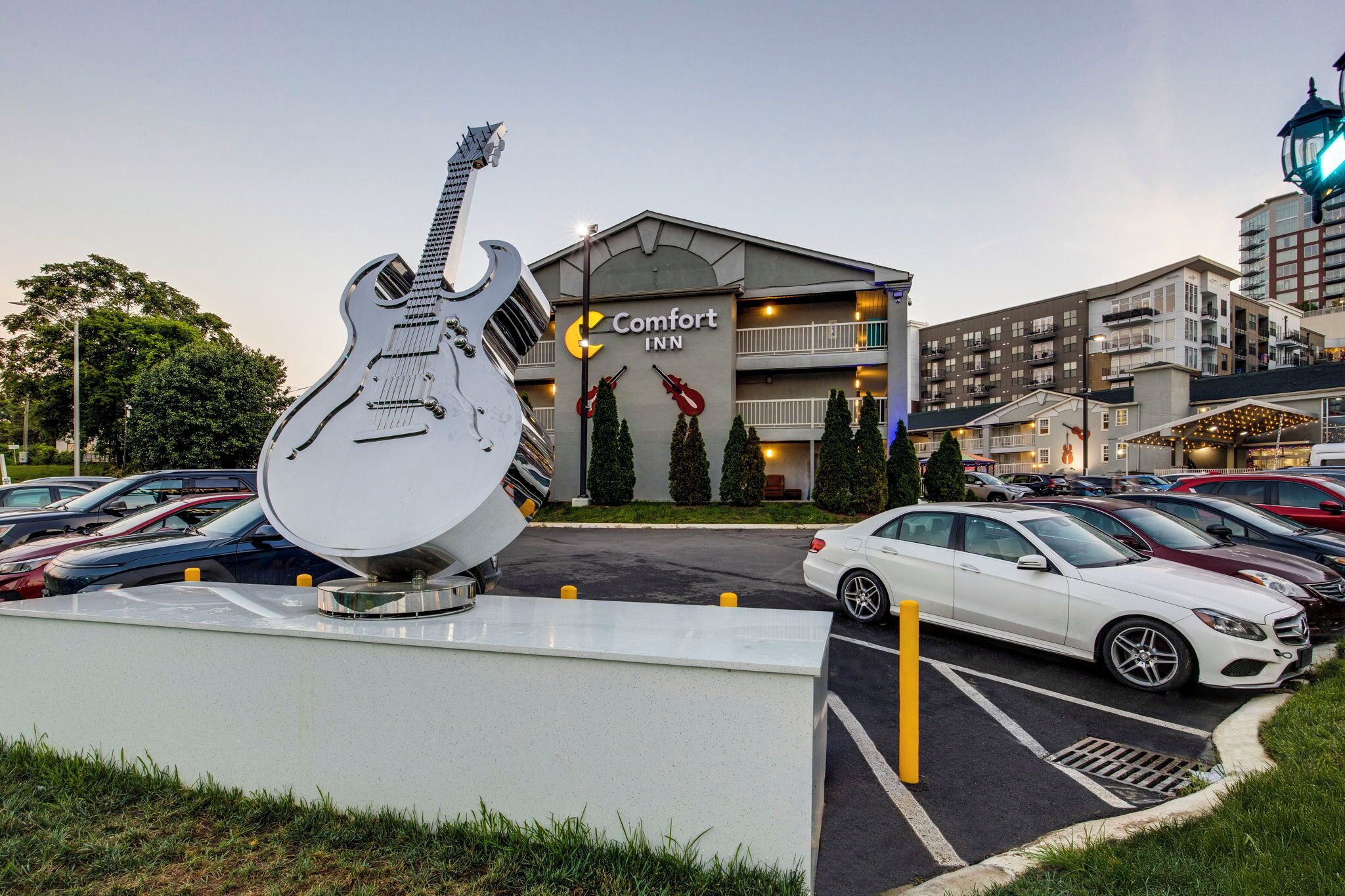 Un hotel Comfort Inn con una gran escultura de guitarra en el estacionamiento.