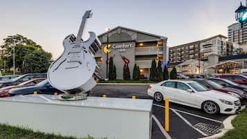Un hotel Comfort Inn con una gran escultura de guitarra en el estacionamiento.