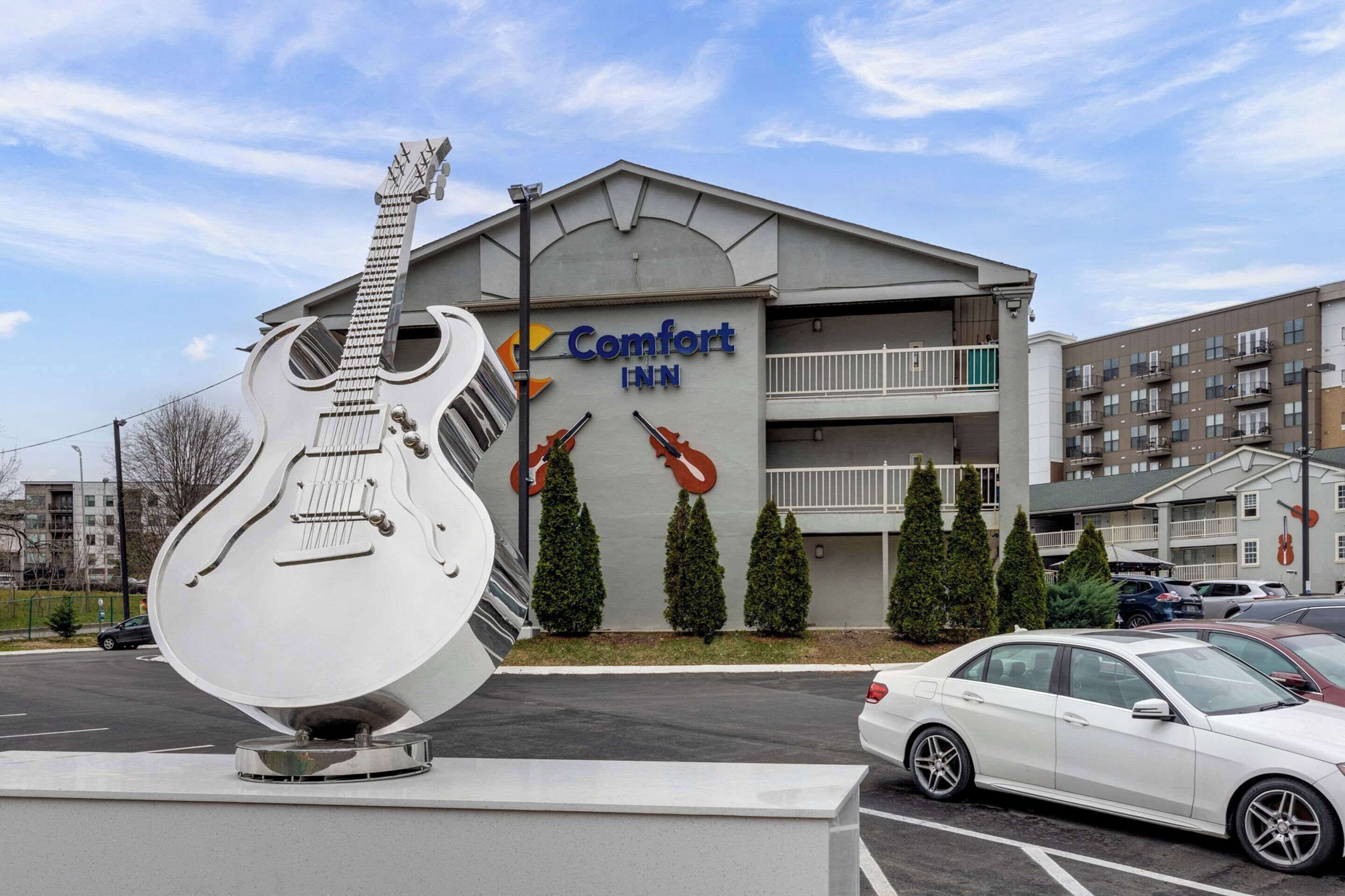 A Comfort Inn hotel with a large guitar sculpture in front.