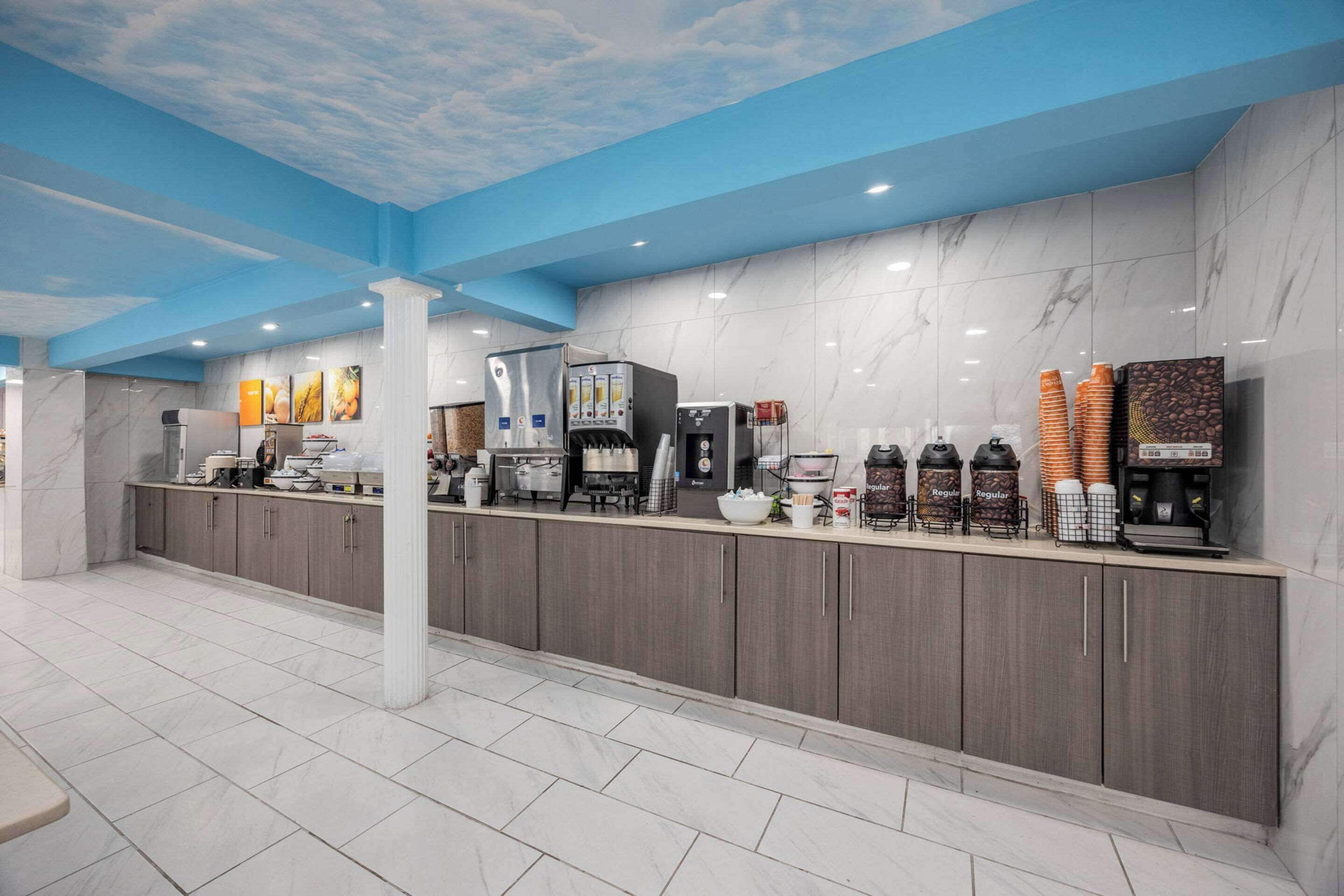 A modern reception area with a marble counter, coffee machines, and a water dispenser.