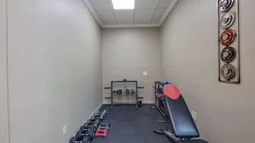 A gym with weight racks, dumbbells, and exercise equipment.