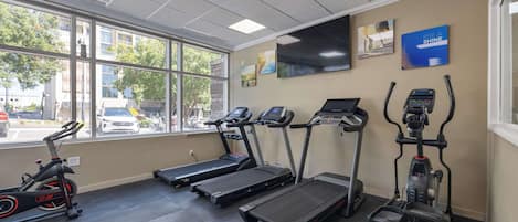Ett gym med löpband, en crosstrainer och en motionscykel.