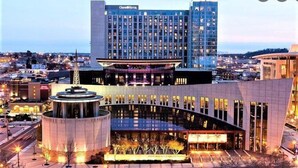 A hotel with a modern design, featuring a prominent central atrium and a large building with multiple windows.