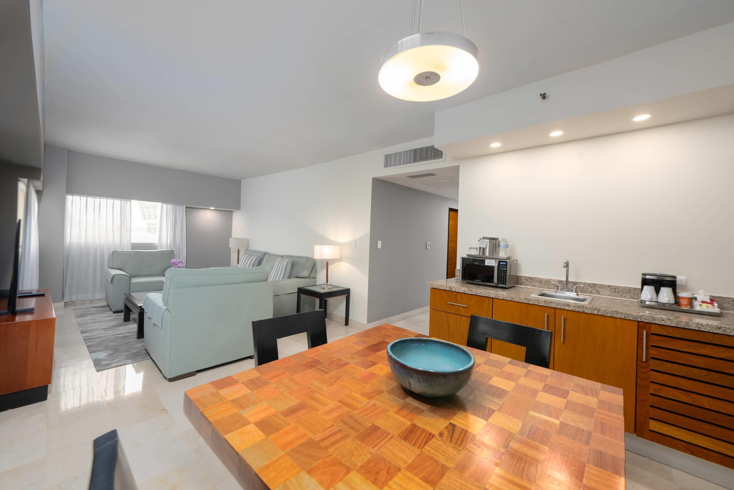 Una cocina moderna con una mesa de comedor, un tazón azul y un sofá en la sala.