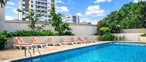 Alberca al aire libre y camastros