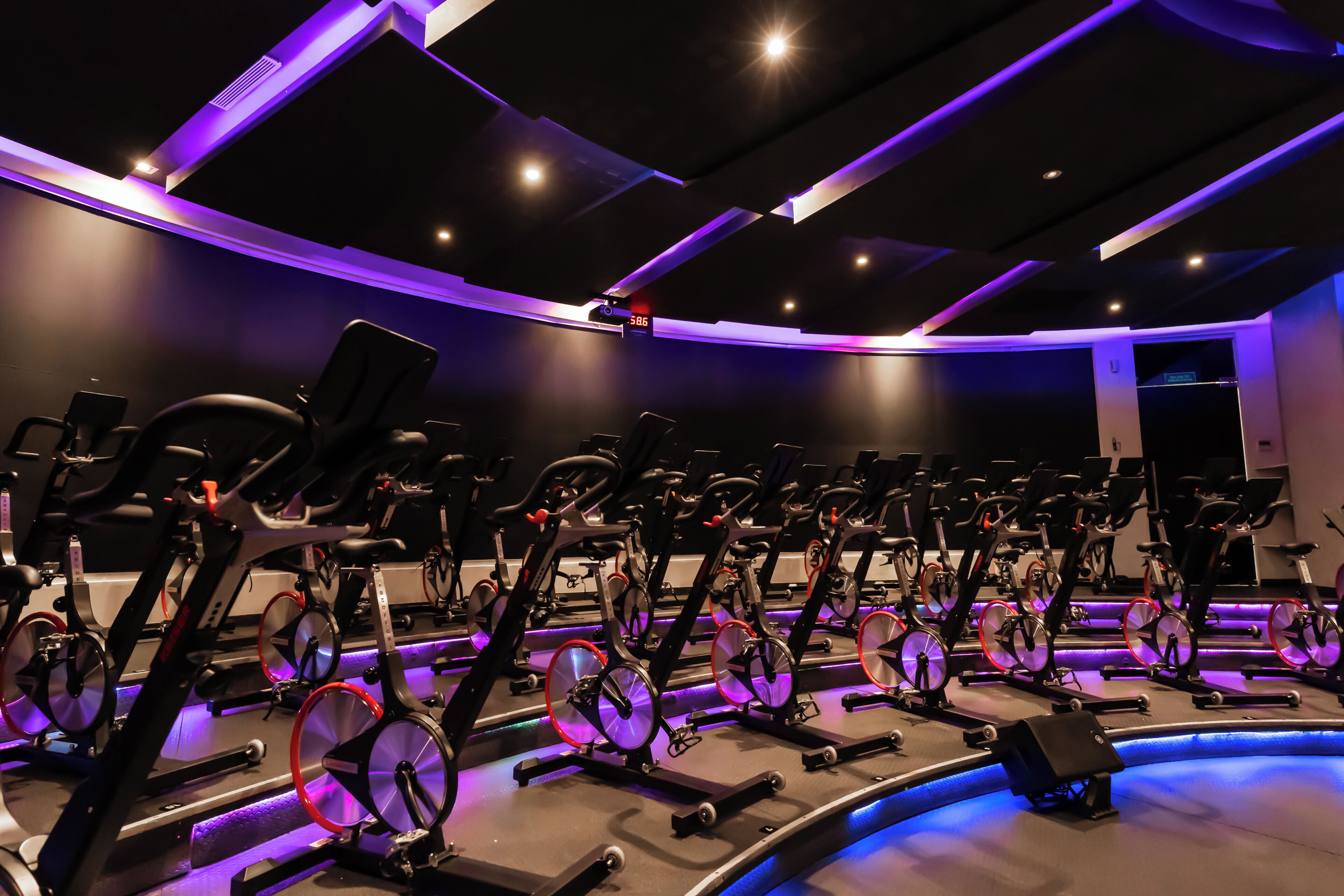 Centro de fitness com várias bicicletas ergométricas dispostas em fileiras.