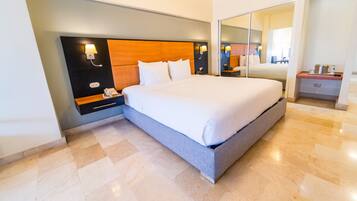 Una habitación de hotel moderna con una cama grande, una mesita de noche, un espejo y una pequeña mesa.