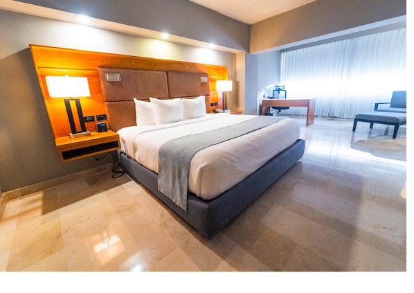 A modern hotel room with a large bed, a desk, and a chair. - Radisson Hotel Santo Domingo (Santo Domingo)