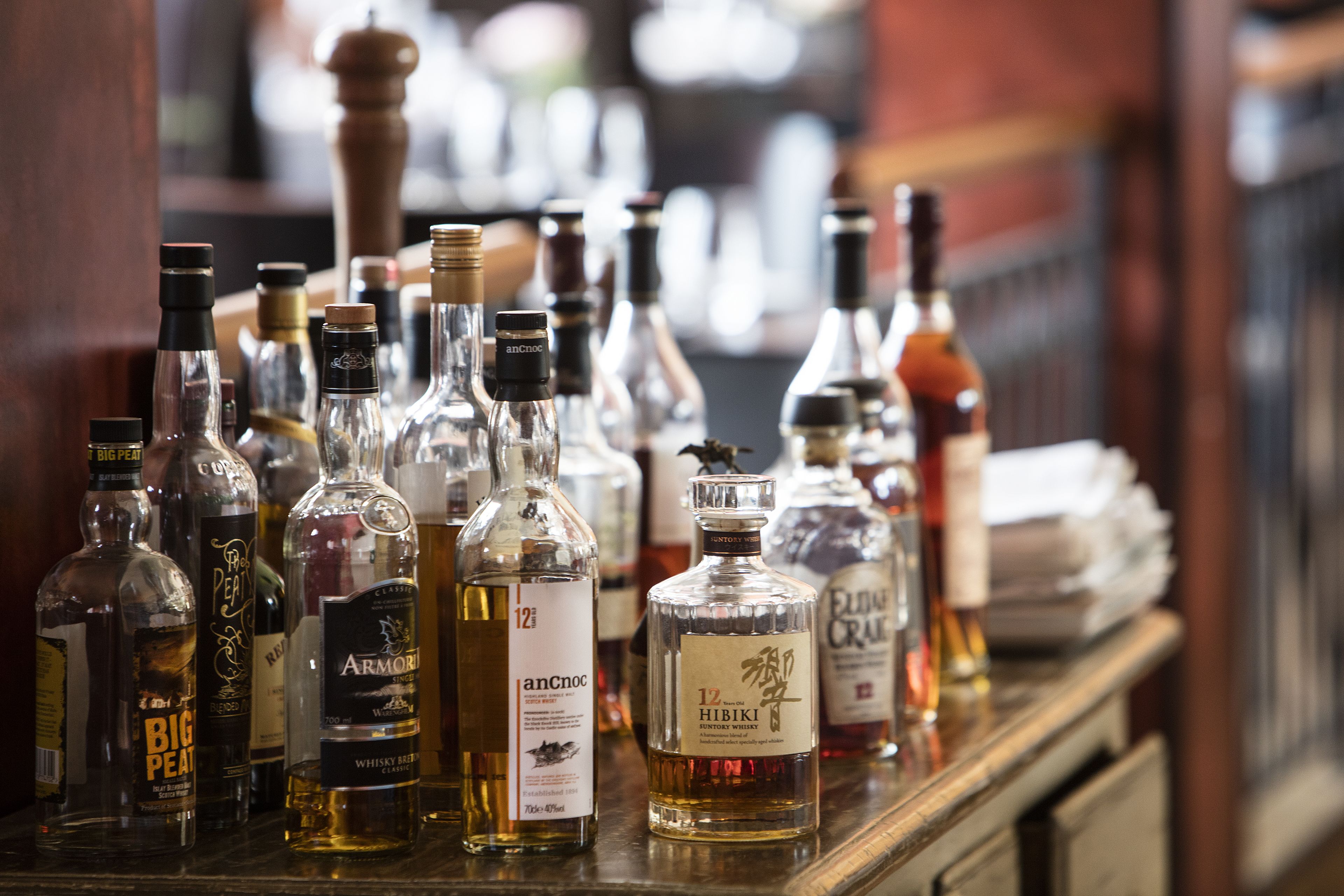 Variedad de botellas de licor sobre una barra.