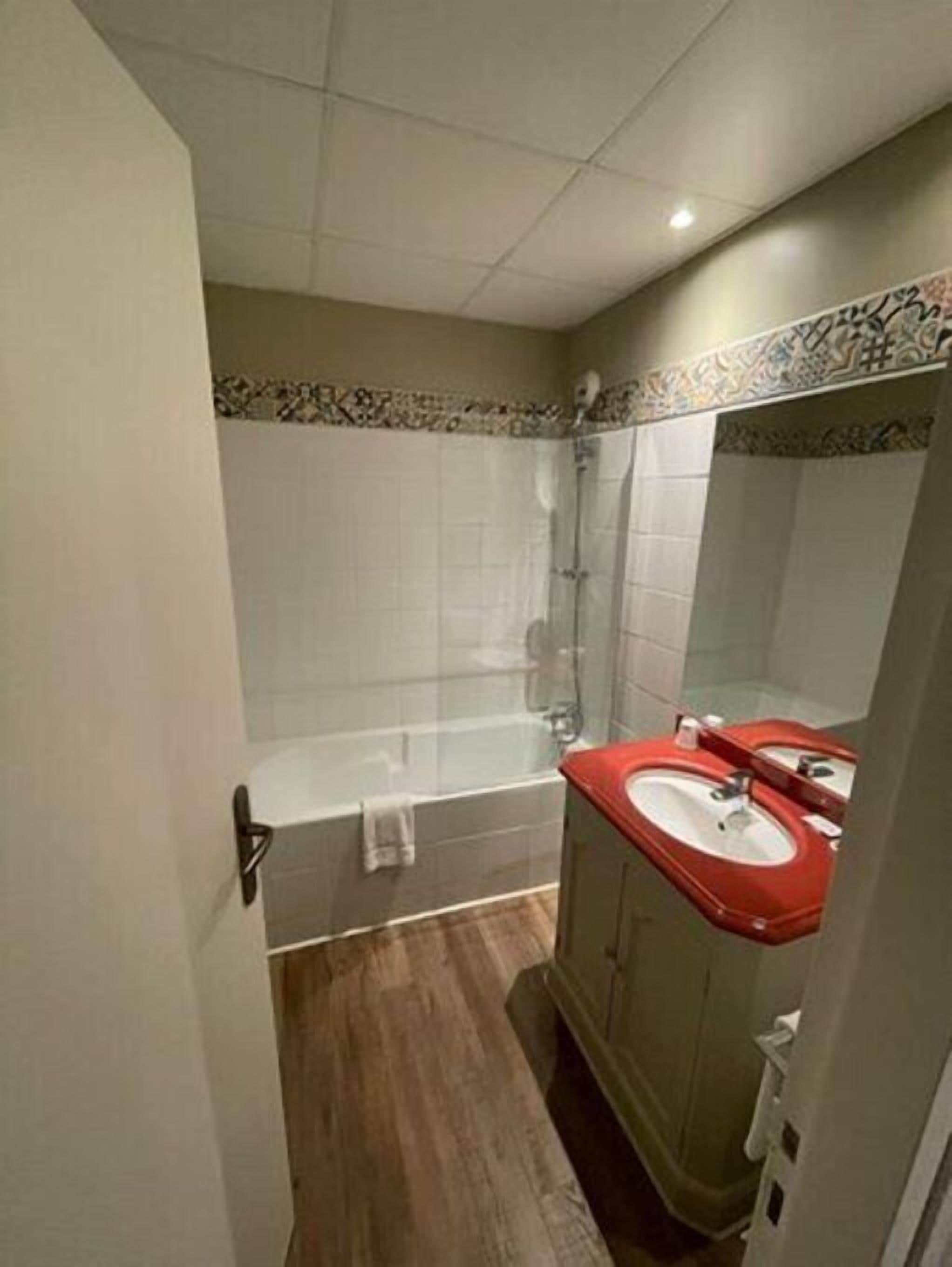 Un baño con bañera, ducha y tocador con espejo.
