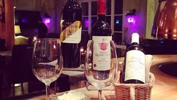 A table with three wine bottles, two glasses, and a candle.
