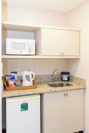 A compact kitchenette with a microwave, kettle, and a small refrigerator. - Comfort Suites Brasilia (Brasília)