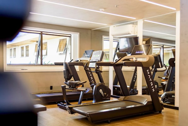 A gym with multiple treadmills and exercise equipment, large windows, and a modern interior design. - Comfort Suites Brasilia (Brasília)
