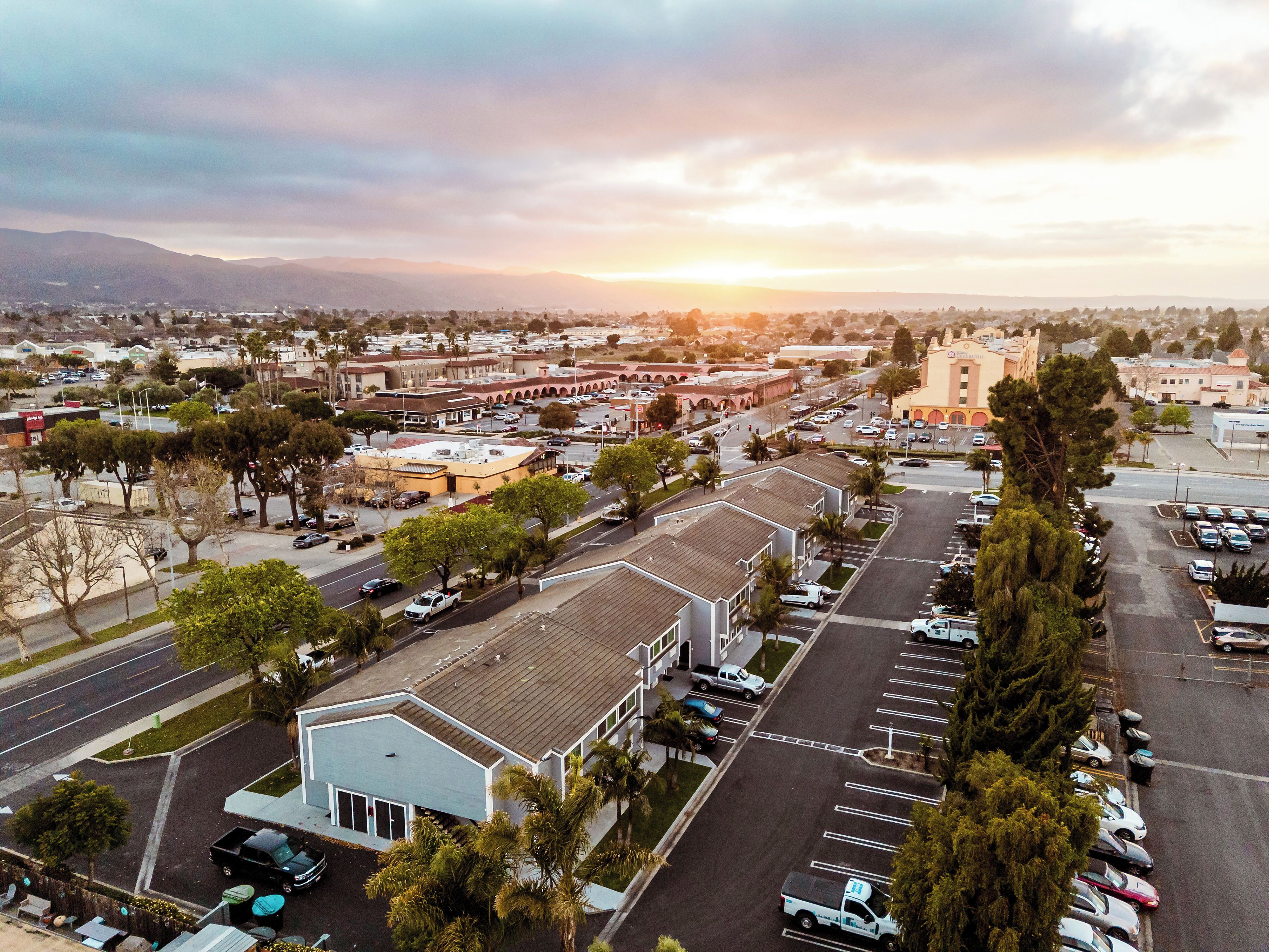 A wide-angle view of a town with a prominent church, parking lots, and a mix of commercial and residential buildings.