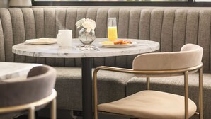 Un comedor con una mesa redonda, un banco acolchado y una silla.