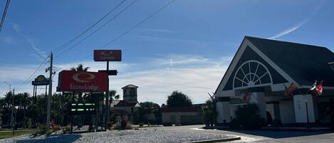 Um hotel com uma placa grande da EconoLodge, uma placa da Days Inn e um edifício com uma janela em arco característica.