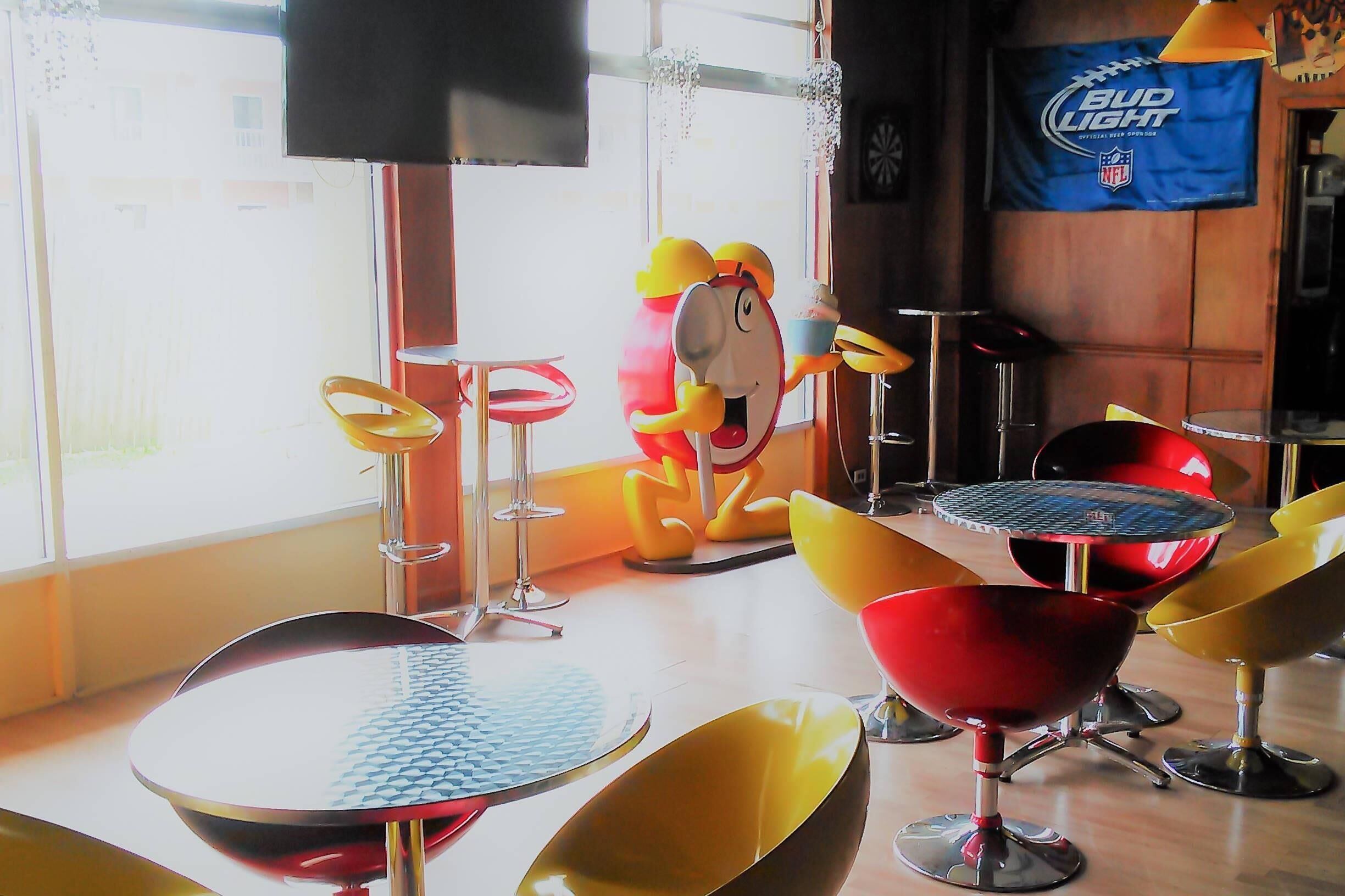 Una habitación con muebles modernos, un ventanal grande y un cartel de Bud Light.