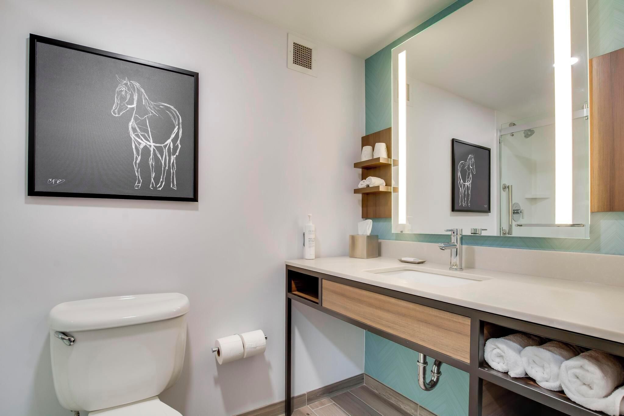 A modern bathroom with a toilet, sink, and towel rack.