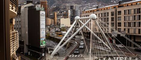 Un puente con la inscripción "Orrà La Vella" y un paisaje urbano con edificios y montañas al fondo.