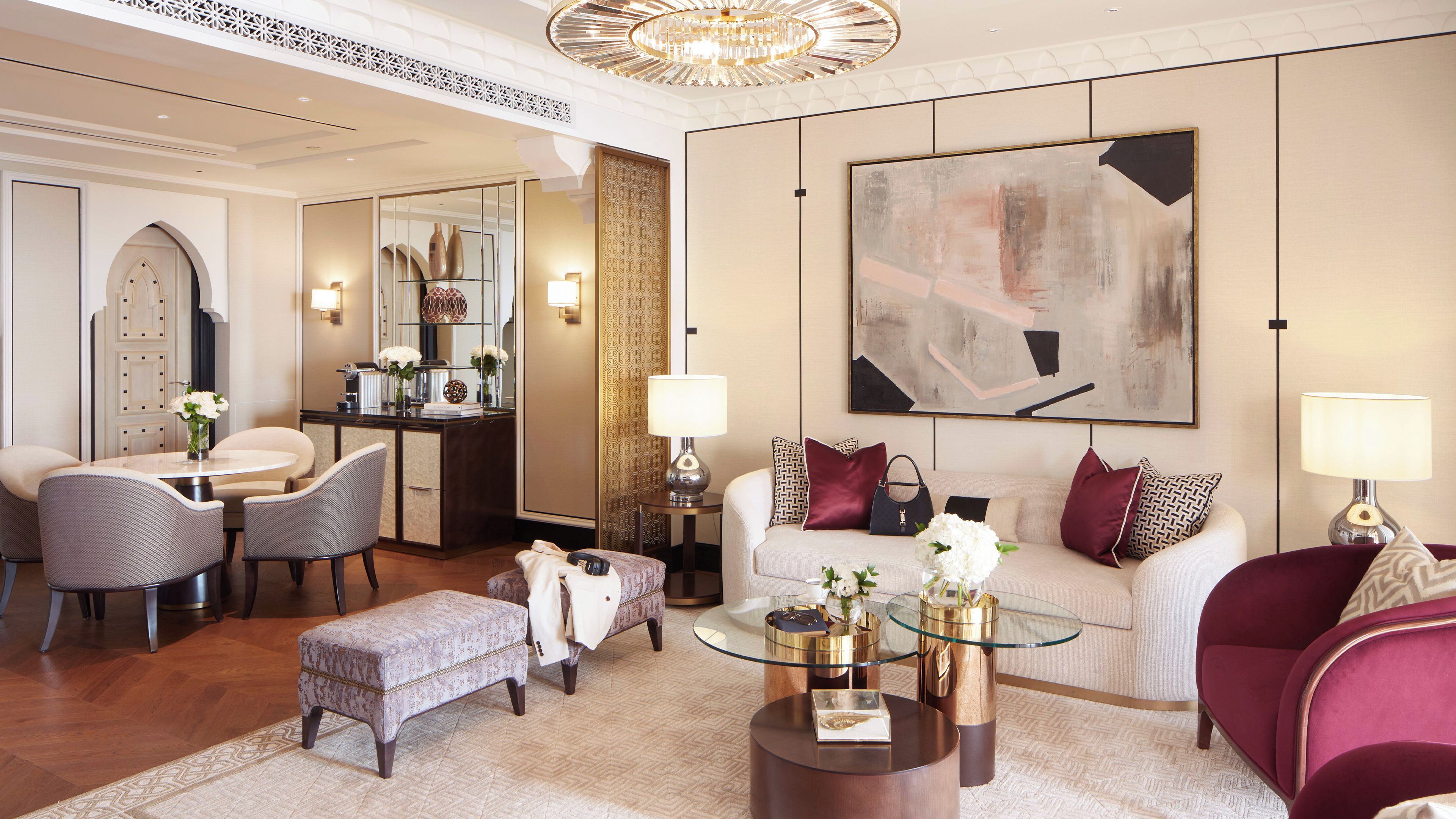 A modern living room with a sofa, armchairs, a coffee table, and a dining area with a table and chairs.