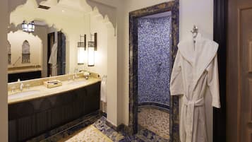 A bathroom with a double sink vanity, a large mirror, and a blue mosaic wall.