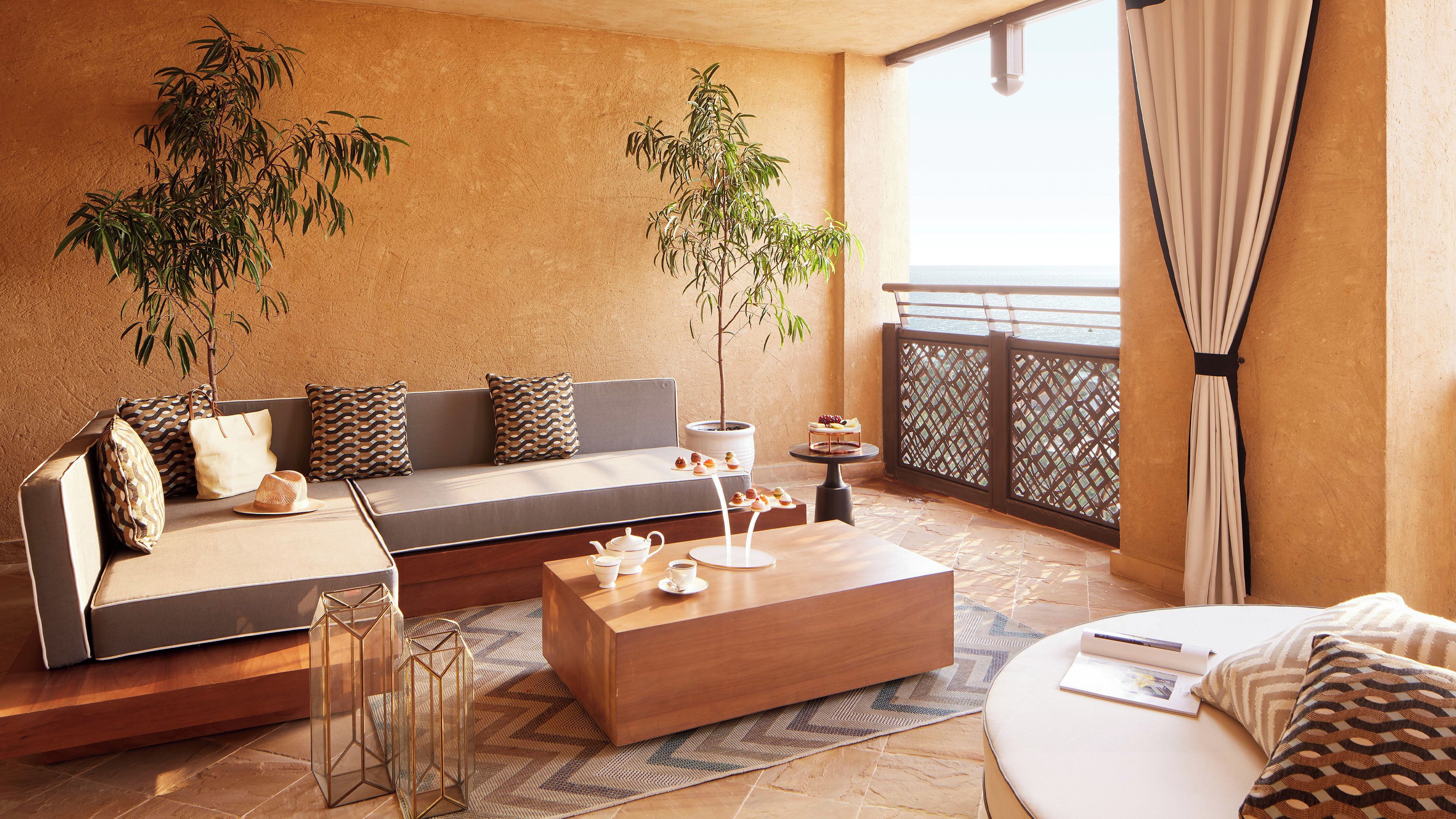 Ein stilvoller Lounge-Bereich mit einer Couch, einem Couchtisch und dekorativen Pflanzen.