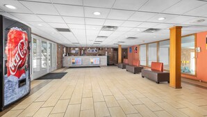 A spacious lobby with a Coca-Cola advertisement, a reception desk, and seating areas.