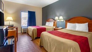 A hotel room with two beds, a desk with a computer, a TV, and a window with a view of the city. - Econo Lodge Lookout Mountain (Chattanooga)