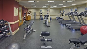 Un centre de remise en forme équipé de tapis de course, de vélos elliptiques et de poids libres.