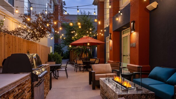 Un patio al aire libre con una barbacoa, zona de estar y una chimenea.