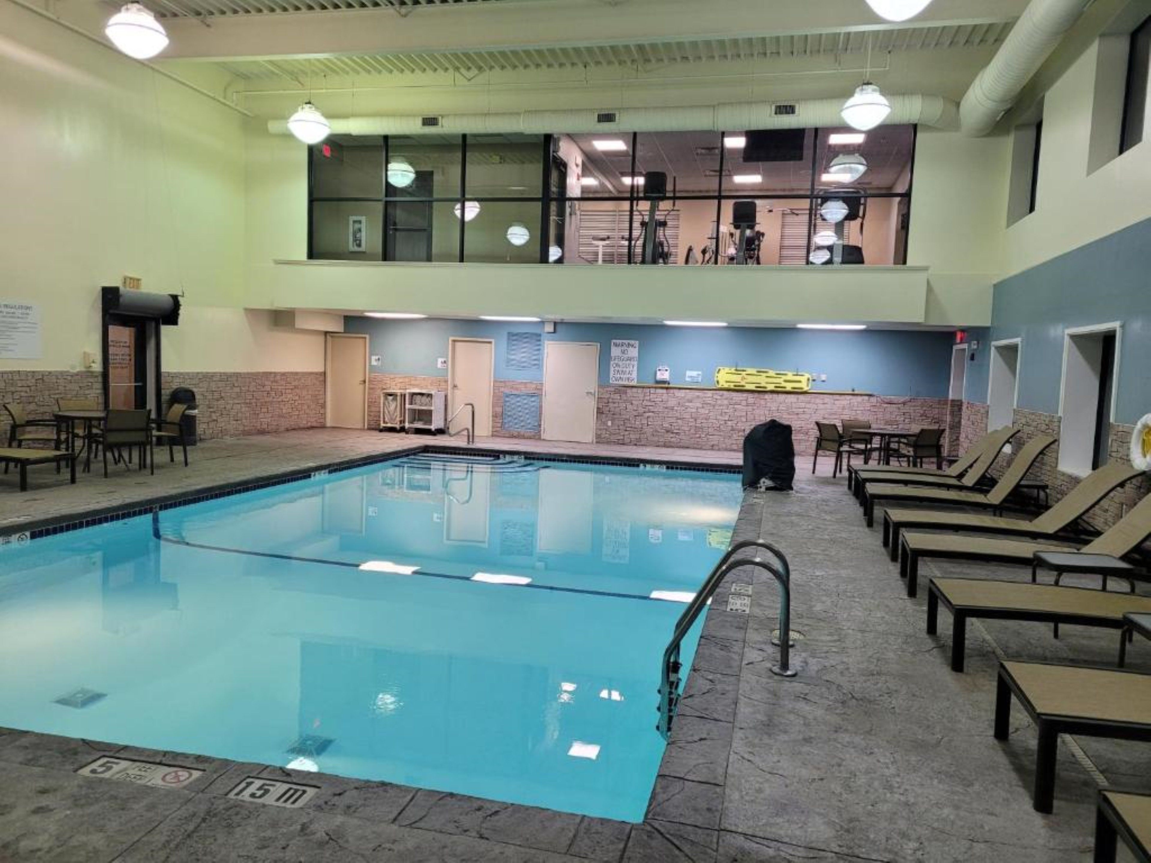 A swimming pool with lounge chairs and a small seating area.