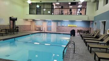 A swimming pool with lounge chairs and a small seating area.