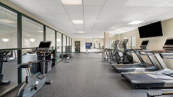 A gym with treadmills, stationary bikes, and exercise equipment.