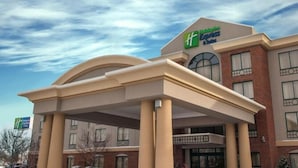 A Holiday Inn Express hotel with a prominent entrance and a clear blue sky.