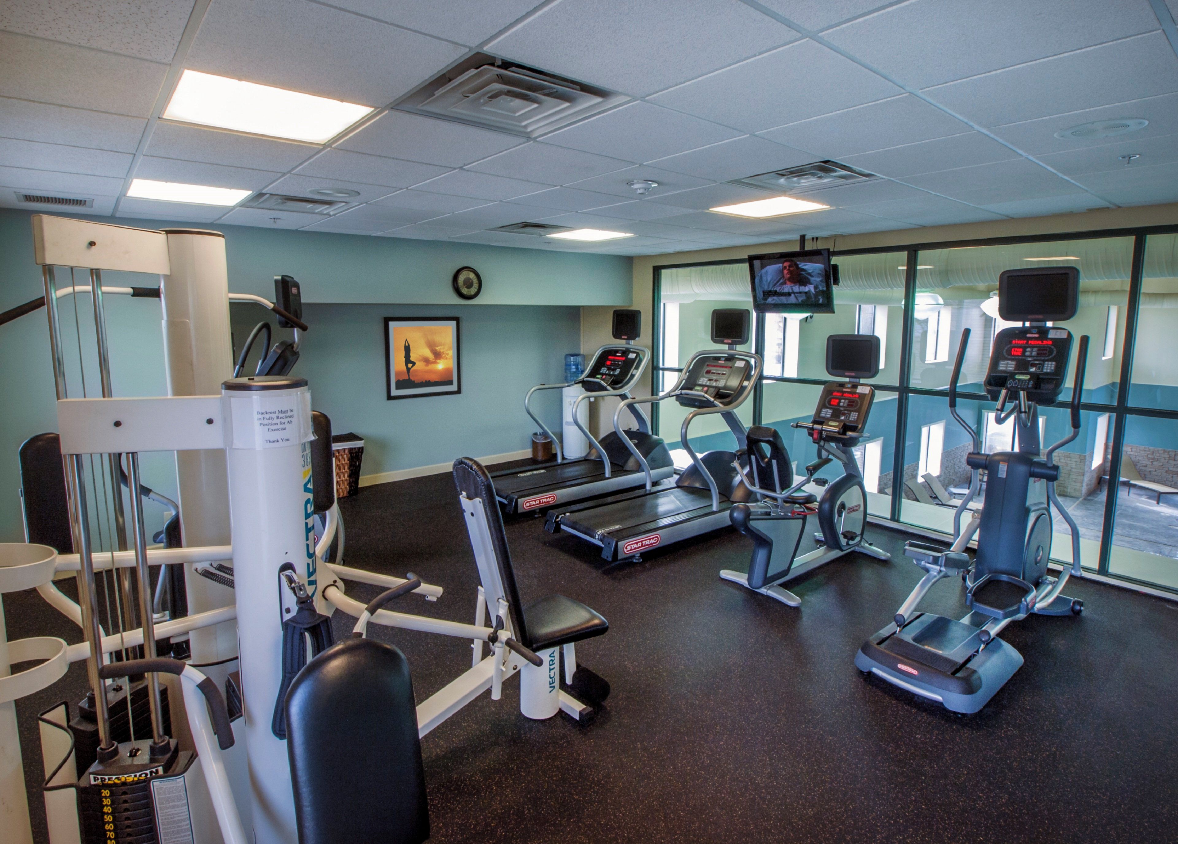 A gym with various exercise equipment, including treadmills and weight machines.