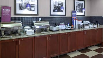 Una cocina de hotel con una barra larga, equipada con diversos electrodomésticos y utensilios.