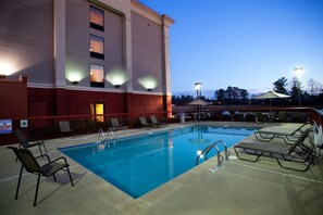 A swimming pool with lounge chairs and a building in the background. - Hampton Inn Carrollton (Carrollton)