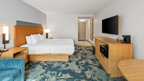 A hotel room with a bed, bedside tables, a desk, a chair, a TV, and a microwave. - Hampton Inn Carrollton (Carrollton)