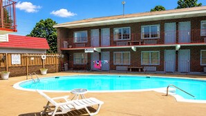 A two-story motel with a swimming pool, outdoor seating, and a fenced yard. - Capt. John Smith Inn (Williamsburg)