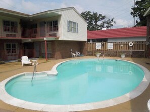 Una piscina al aire libre de temporada, sombrillas, tumbonas
