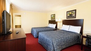 A hotel room with two beds, a TV, a desk, and a red carpet. - Capt. John Smith Inn (Williamsburg)