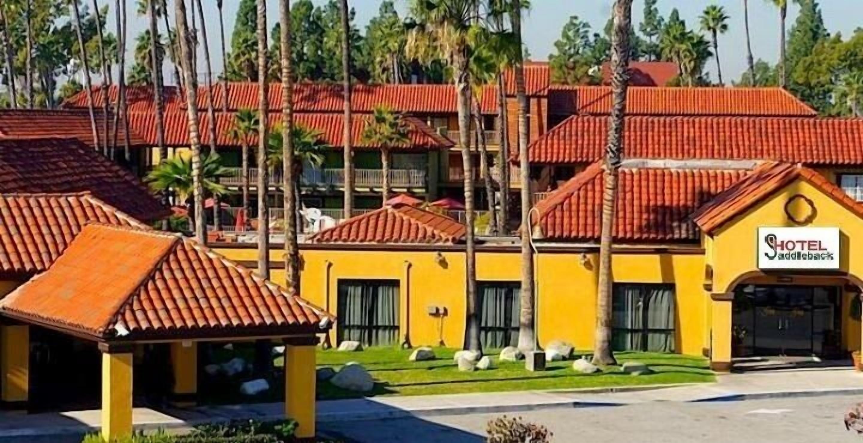 Hotel com vários edifícios, telhados de telhas vermelhas e paredes amarelas.